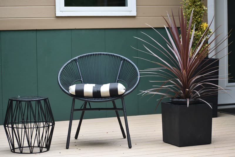 Grey composite deck boards with patio chairs and a planter